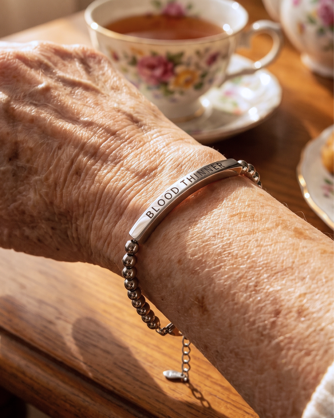 Woman wearing a blood thinner medical alert bracelet with a cup of tea
